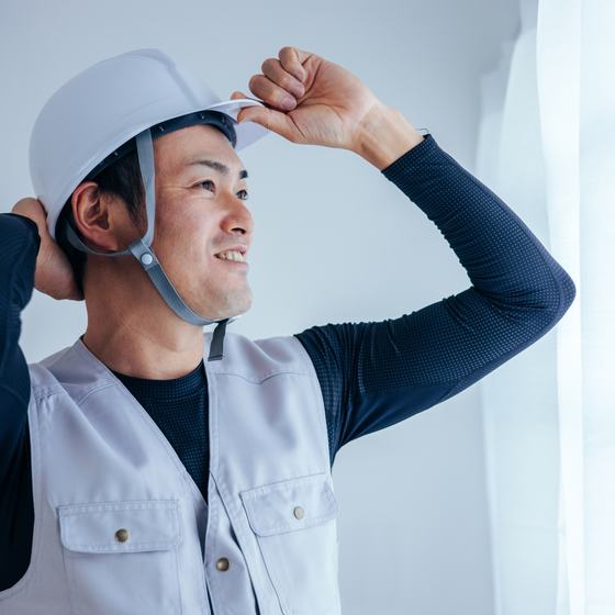 ヘルメットをかぶって現場を確認する職人