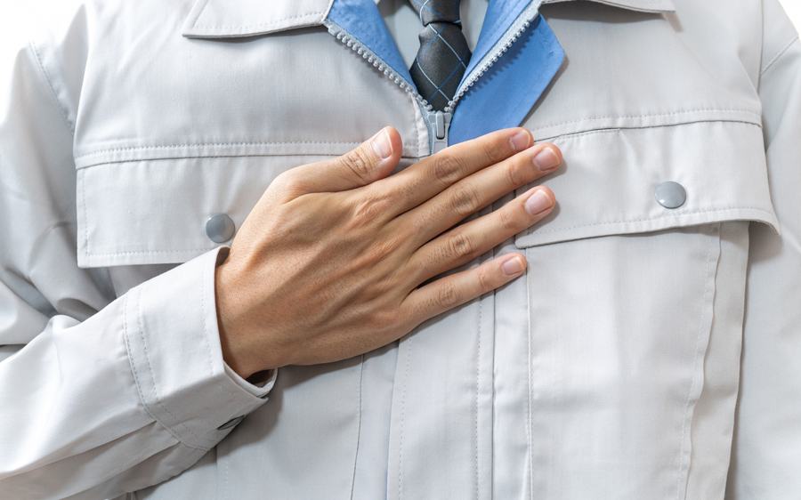 作業服の職人が胸に手をあてている様子